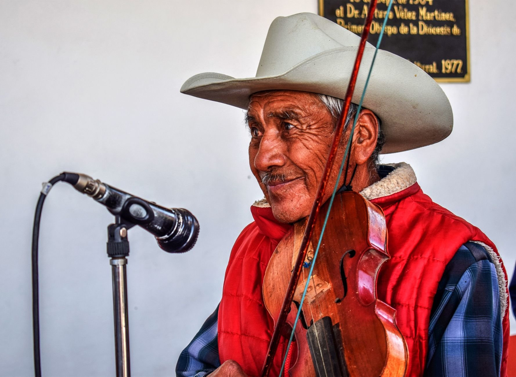 Smiling elderly man with violin performing — the joy Band Together families bring to their audiences